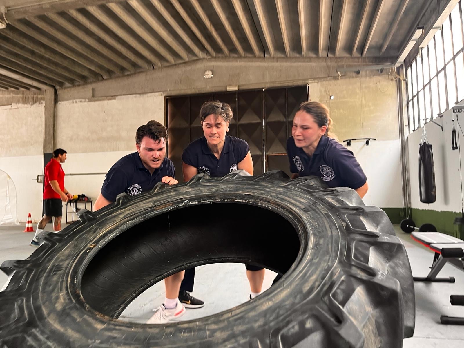 AREMT European Office — Team tyre flip physical conditioning exercise